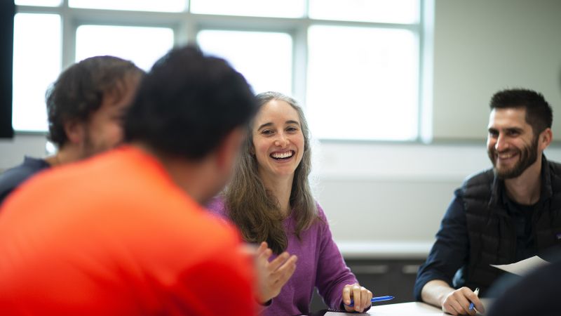 four people sitting at a table talking