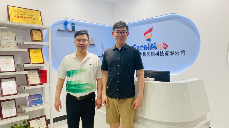 Dr Shunfei Yan at the front desk of ExcelMab with a second person