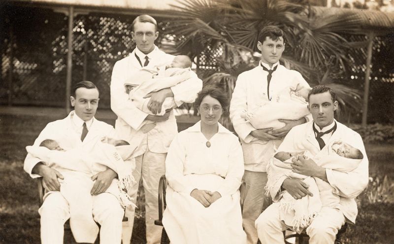 Early students from the medical faculty cradling newborns