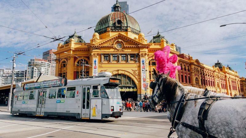 Flindest street station in Melbourne with a tram and horse in foreground