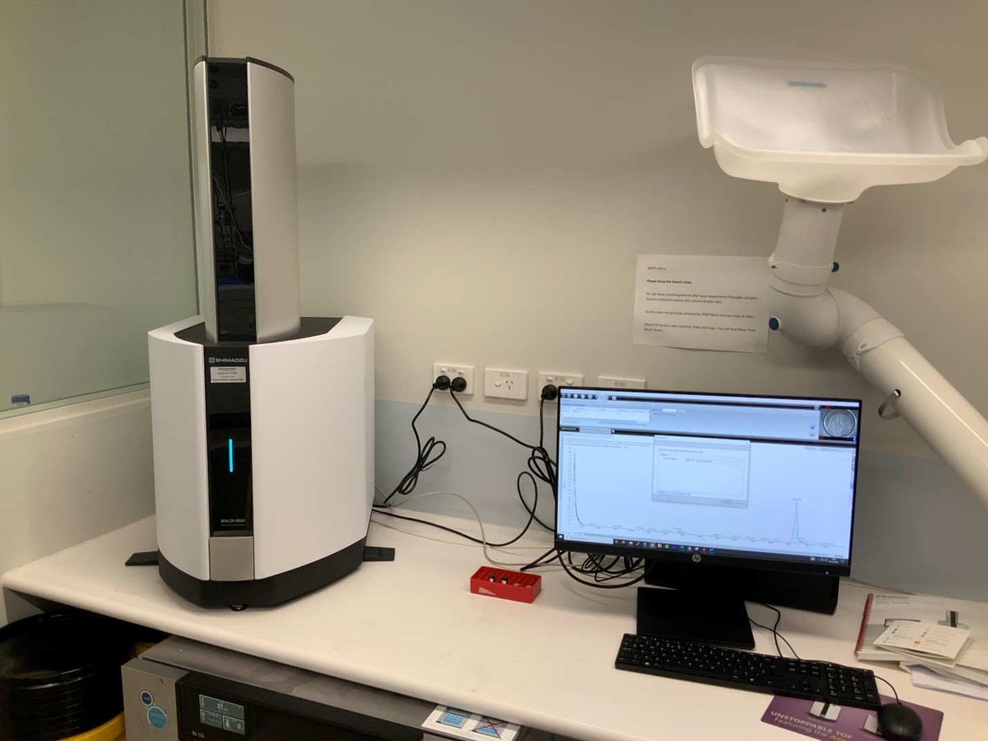 Shumadzu 8020 MALDI-TOF instrument on a lab bench with a computer.