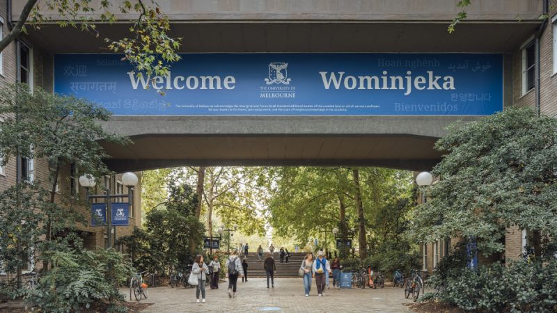 A University of Melbourne sign above a campus entrance reading welcome, wominjeka and the same word in other languages