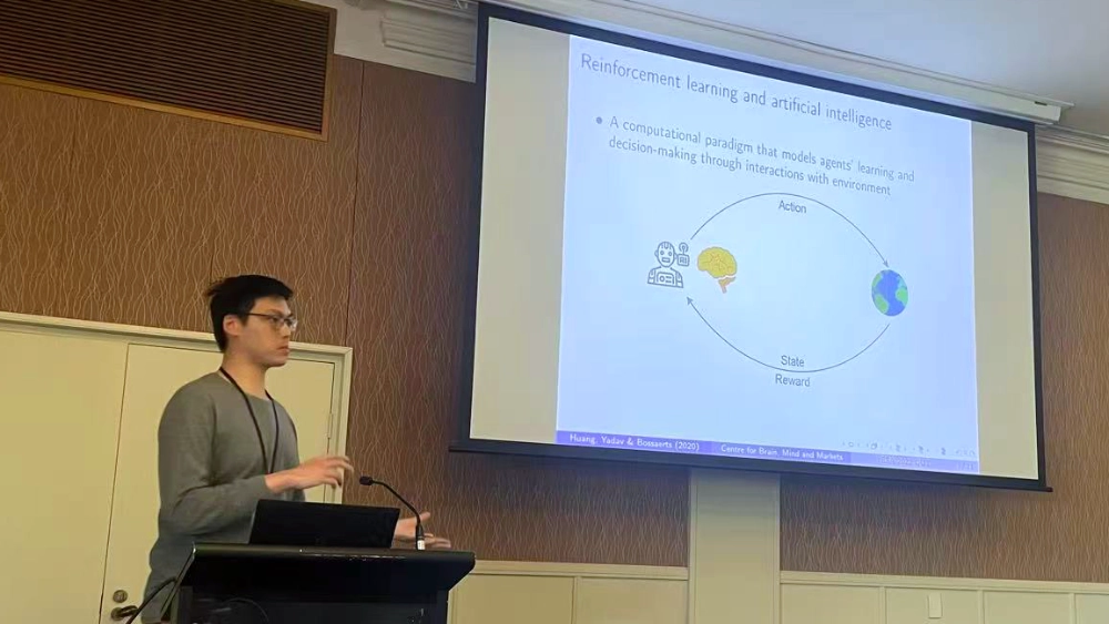 Harvey Huang speaks at a conference about reinforcement learning and artificial intelligence