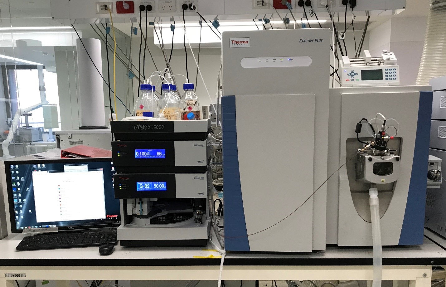 Thermo Orbitrap Exactive Plus large instrument on a lab bench beside a computer monitor.