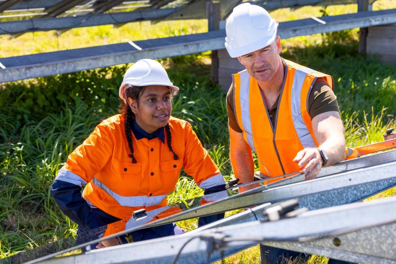 An Indigenous sustainability researcher works on a solar panel