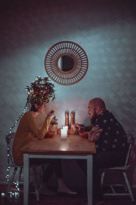 a woman and man sitting across from each other at a kitchen table
