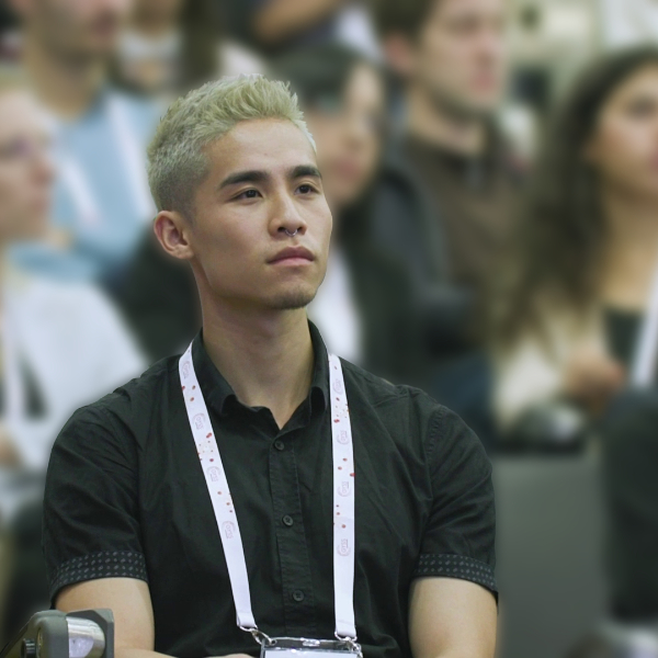 Vincent Liu, an Asian man with blonde hair, concentrates on a lecture