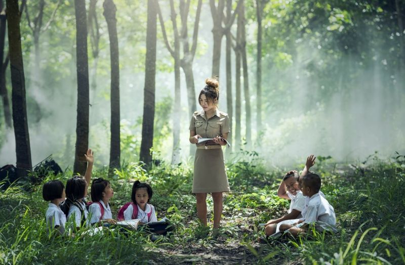 Teacher and her kinder class enjoying a lesson in the forest