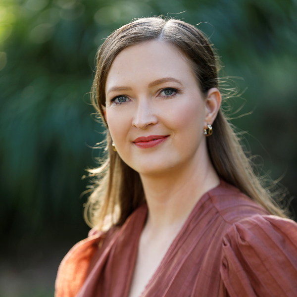 Anna Kennedy-Borissow, a white woman with dark blonde hair, smiles gently in sunshine